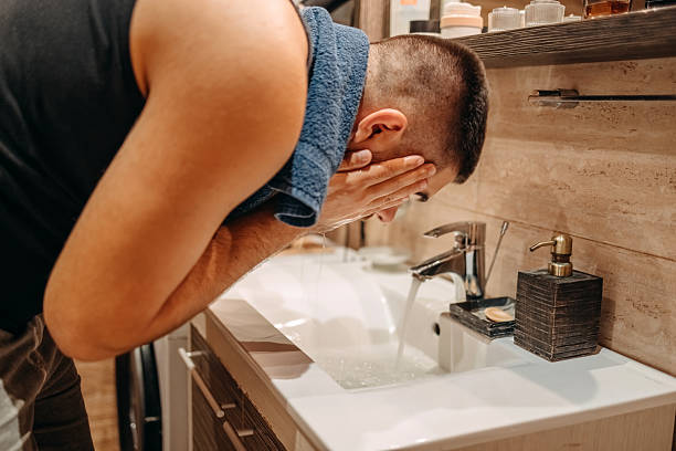 istock Young man at home standing in front of mirror in bathroom and doing morning routine 2236855367