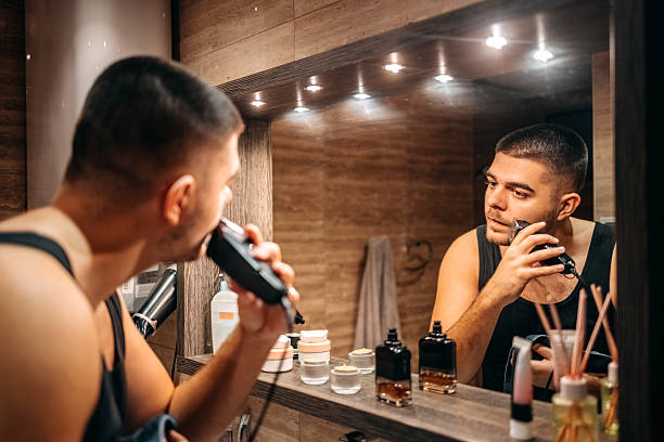 istock Young man at home standing in front of mirror in bathroom and doing morning routine 2236855495