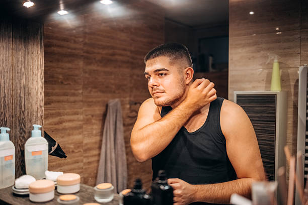 istock Young man at home standing in front of mirror in bathroom and doing morning routine 2236855659