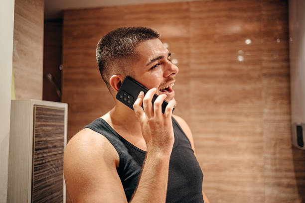 istock Young man at home standing in front of mirror in bathroom and doing morning routine 2236855673