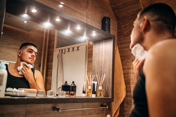 istock Young man at home standing in front of mirror in bathroom and doing morning routine 2236855683