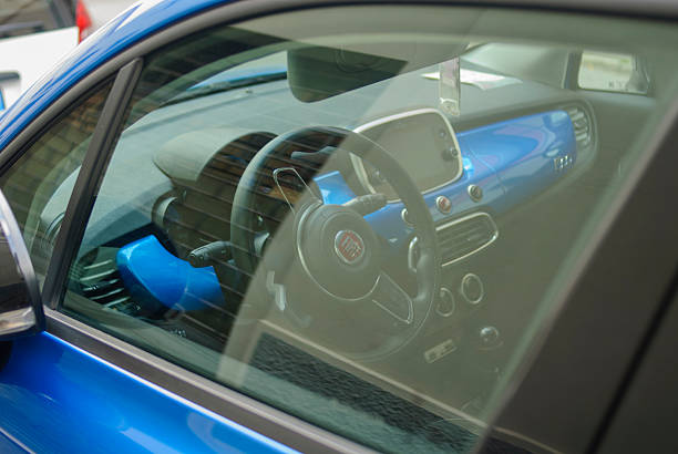 Cremona, Italy - September 21st 2025 Fiat 500X urban car interior with blue dashboard and steering wheel, reflecting sunlight, emphasizing modern vehicle design and style for city driving and personal