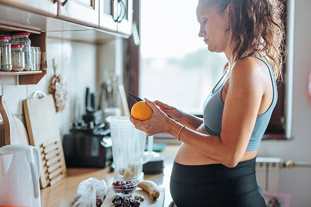 istock Pregnant woman preparing healthy fruit smoothie in kitchen 2236861759