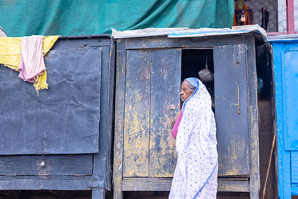Varanasi, Uttar Pradesh, India - March 2024: Portrait of an indian unidentified old woman vendor selling  products on the ghats near river ganga at harishcnadra ghat in varanasi.