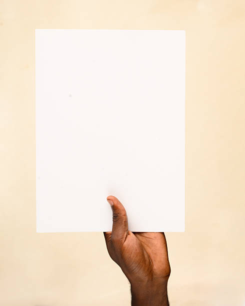istock Hand holding blank vertical paper sheet on beige background 2236862109