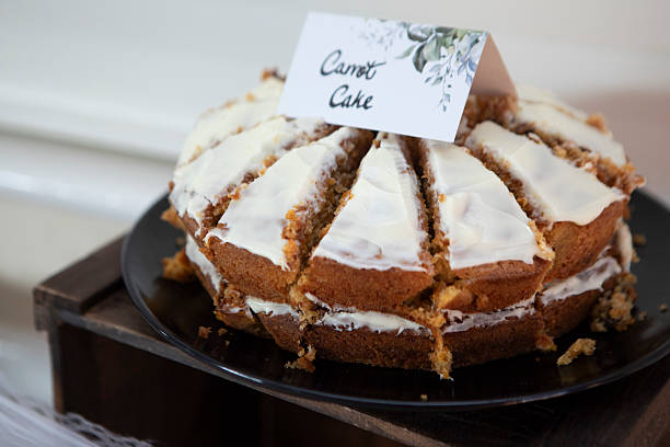 Homemade carrot cake with mascarpone cream cheese icing and mini marzipan carrot decorations isolated on white background