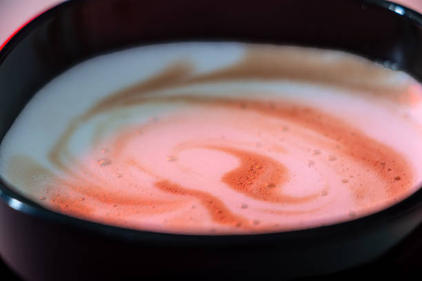This close-up photo shows a cup of creamy coffee. The minimalist style and warm colors evoke a feeling of peace and quiet enjoyment.