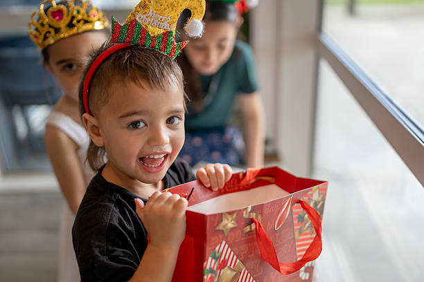 Smiling Child Holding Christmas Gift Bag