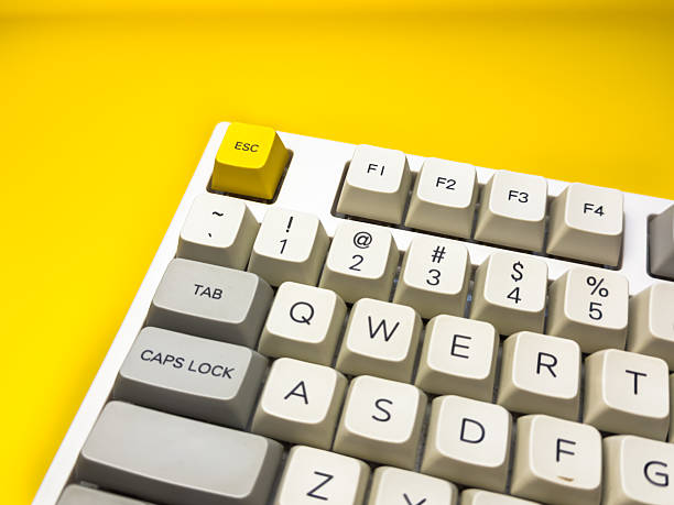 istock White mechanical keyboard with bright Esc key on bright yellow background, minimalism, keyboard buttons. A keyboard with a yellow key on the bottom left 2236869277