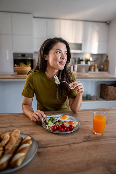 istock Woman eating healthy breakfast looking away smiling 2236874824