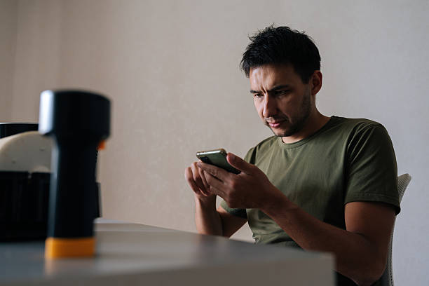 istock Puzzled technician reading instructions on smartphone while cleaning filter of modern air humidifier, ensuring proper maintenance and optimal performance. 2236878533