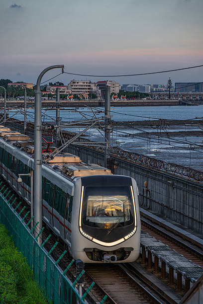 istock A modern light rail train travels along an elevated track during twilight in an urban setting with a waterfront view 2236878657