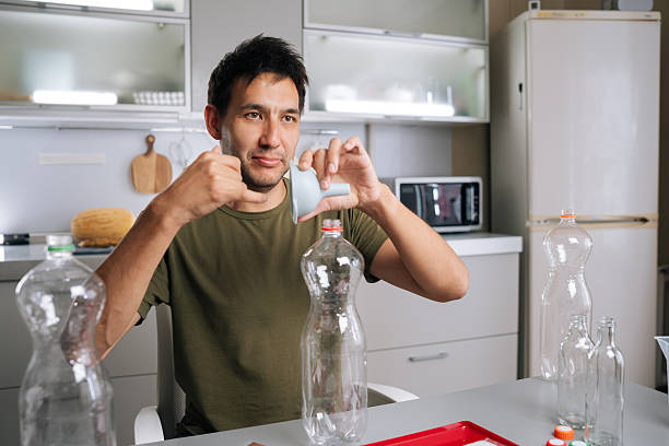istock Gardener pouring organic fertilizer through funnel into plastic bottle, mixing nutrient-rich solution for healthy garden plants. 2236879545
