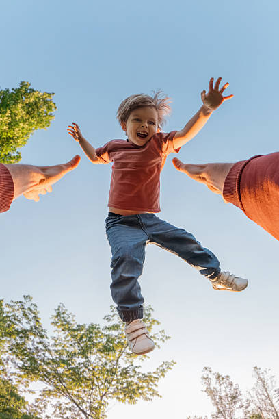 istock POV view, a father high throws and catches his laughing son in a park. 2236880840