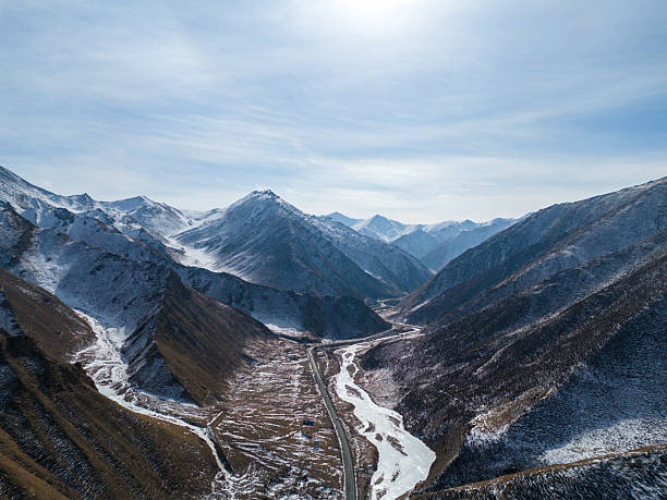 istock Winding Road Through a Snow-Capped Mountain Valley Under a Clear Sky 2236882397