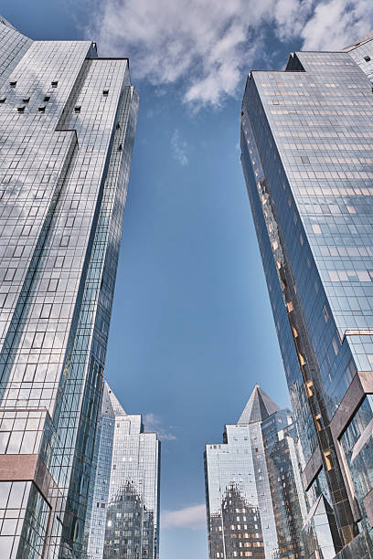 istock Modern glass skyscrapers reflecting blue sky and clouds 2236884900