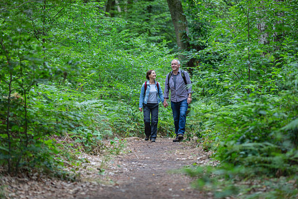 Hiking - senior couple walking through the forest
