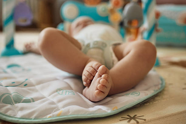 istock Baby lying on a play mat wearing a diaper 2236885136