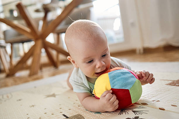 istock Baby playing on playmat, exploring colorful toy 2236889881