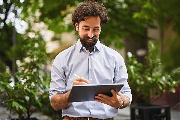 istock Businessman working with tablet and pen outdoors in urban setting 2236890271