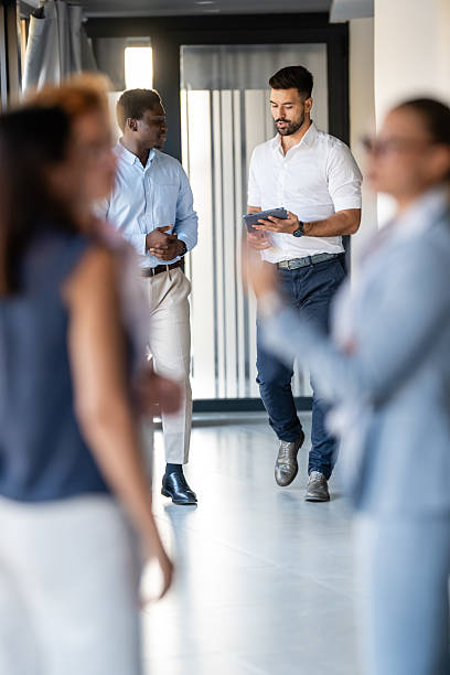 istock Business professionals networking and collaborating in modern office hallway 2236894561