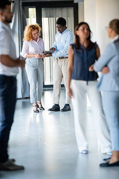 istock Diverse business professionals networking in modern office hallway 2236894631