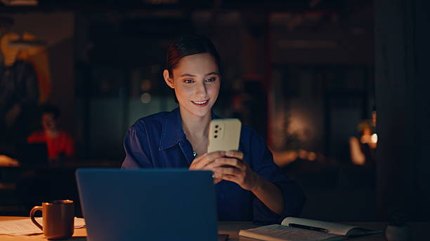 istock Manager ordering online purchase by cellphone app in night office closeup. 2236895441