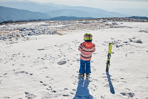 Beautiful girl on skiing, relaxing on the top of the mountain. Copy space.