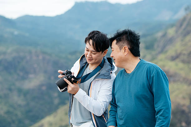 istock Travelers Smiling While Reviewing Photos on Digital Camera 2236897789