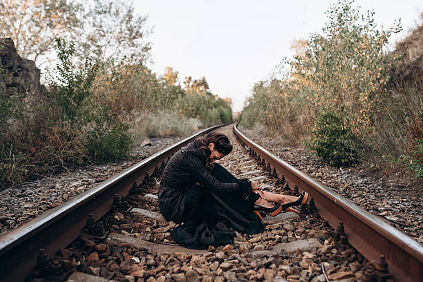 istock Woman Sitting Alone on Train Tracks in Nature 2236899267