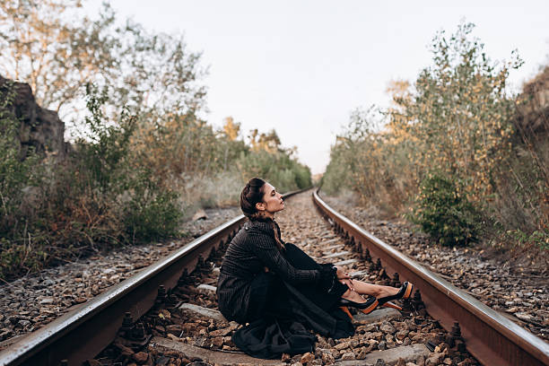 istock Woman Sitting Alone on Train Tracks in Nature 2236899454