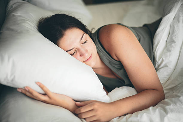 istock Beautiful young woman sleeping on a bed with white bed linen 2236901877