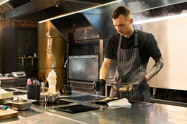 istock Young Caucasian Man Cooking Gourmet Dish in Professional Restaurant Kitchen 2236902545