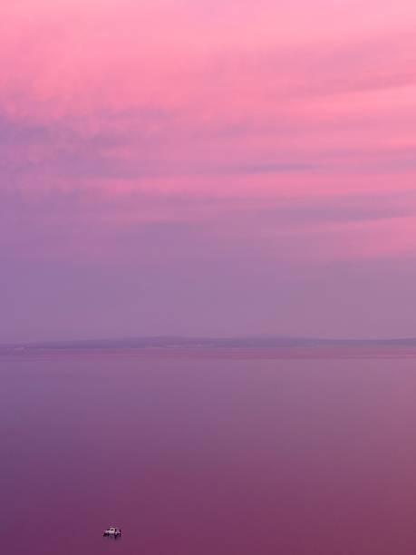 istock Pink Sunset Seascape with Small Boat 2236905668