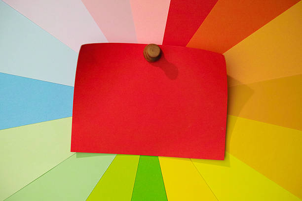 Blank red note paper, pinned to a colorful array of background blank message notes that radiate around the blank note in a rainbow spiral effect. Conceptual message, sign board, sign for copy space, etc.