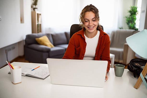 istock Young woman studying at home with a laptop and enjoying her workspace 2236906152