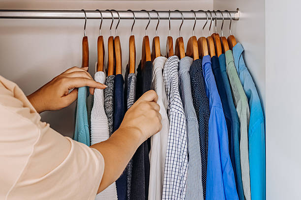 istock Hand choosing clothes in organized wardrobe 2236907423