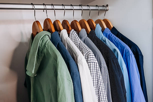istock Neatly arranged shirts hanging in wardrobe 2236907456