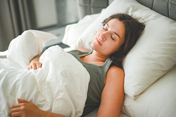 istock Beautiful young woman sleeping on a bed with white bed linen 2236908248