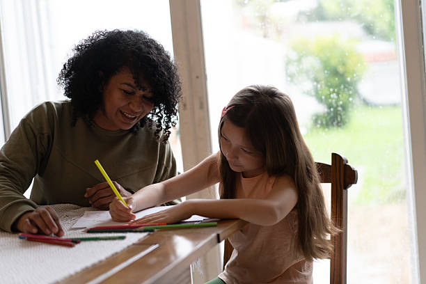istock Caregiver and girl making her homework 2236911360