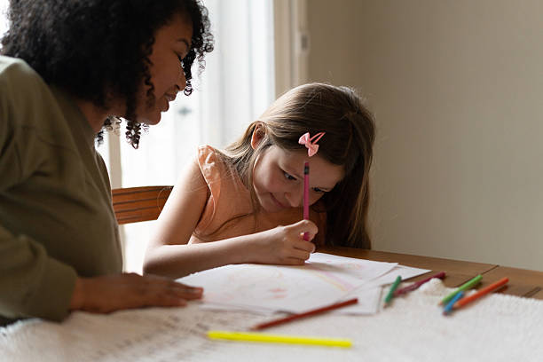 istock Caregiver and girl making  homework 2236911375