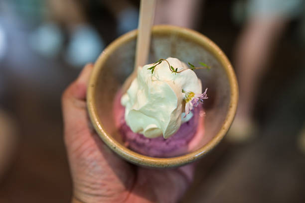 Holding a ice cream cup on top with whipped cream on a summer day