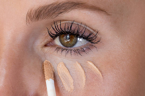 istock Female appyling concealer her under eyes 2236912032