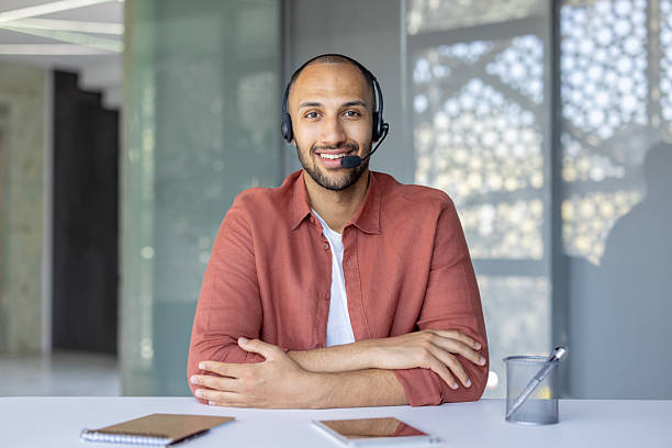 istock Happy customer service agent smiles, wearing headset at modern office desk 2236912465