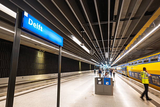 Delft, Netherlands, August 26, 2025. People and NS train inside underground station platform, wide angle view