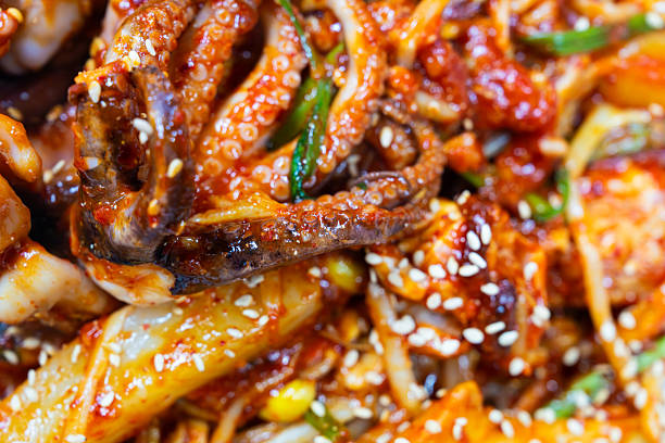 braised spicy seafood including various seafoods and vegetable. Haemul-jjim (Korean spicy braised seafood) is a popular dish made with various seafood like crab, shrimp, and squid, along with vegetables such as bean sprouts and water parsley. It is stir-fried in a thick, spicy sauce made from red chili powder and other seasonings.