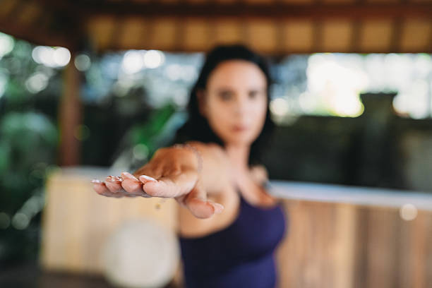 Woman performing a yoga pose, extending her arm forward, cultivating focus and balance in a serene environment