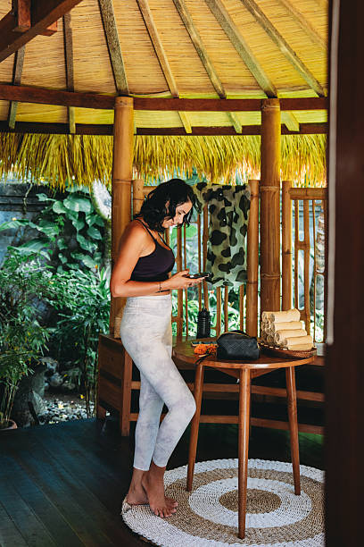 istock Woman using smartphone in tropical bamboo retreat 2236914695