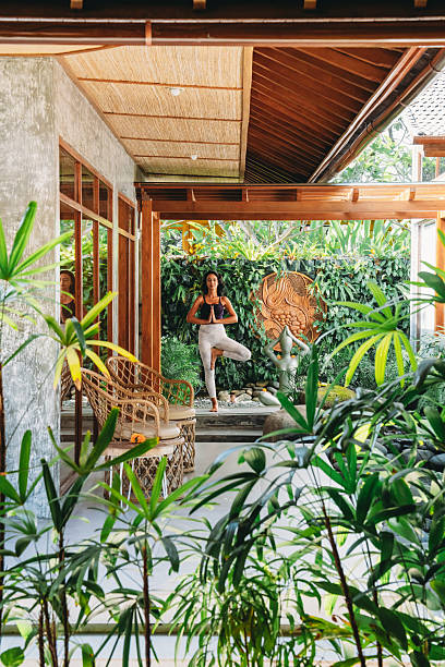 istock Woman practicing yoga tree pose in tropical Balinese garden 2236914761