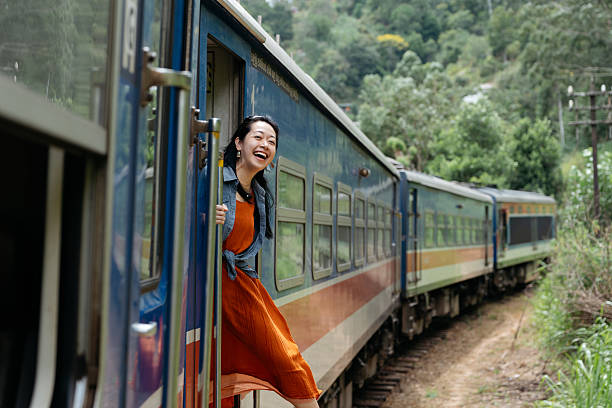 A happy traveler leaning out of a train door, embracing the fresh air and scenic beauty of tea fields. The image conveys the joy of slow travel, cultural immersion, and breathtaking landscapes, perfect for promoting tourism, eco-travel, and destination experiences.